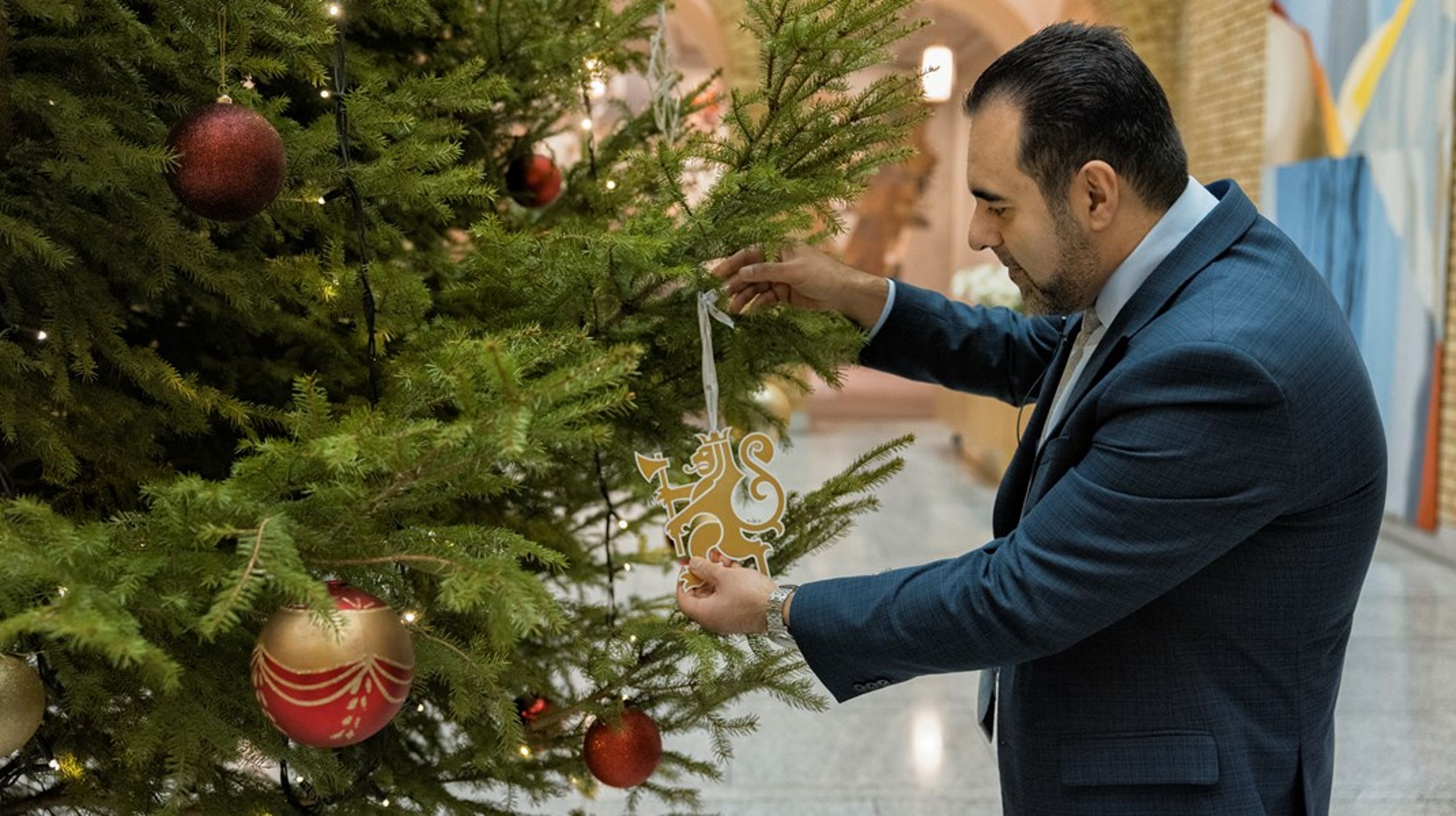 <div>Stortingspresident Masud Gharahkhani henger julepynt på juletreet i vandrehallen.</div>