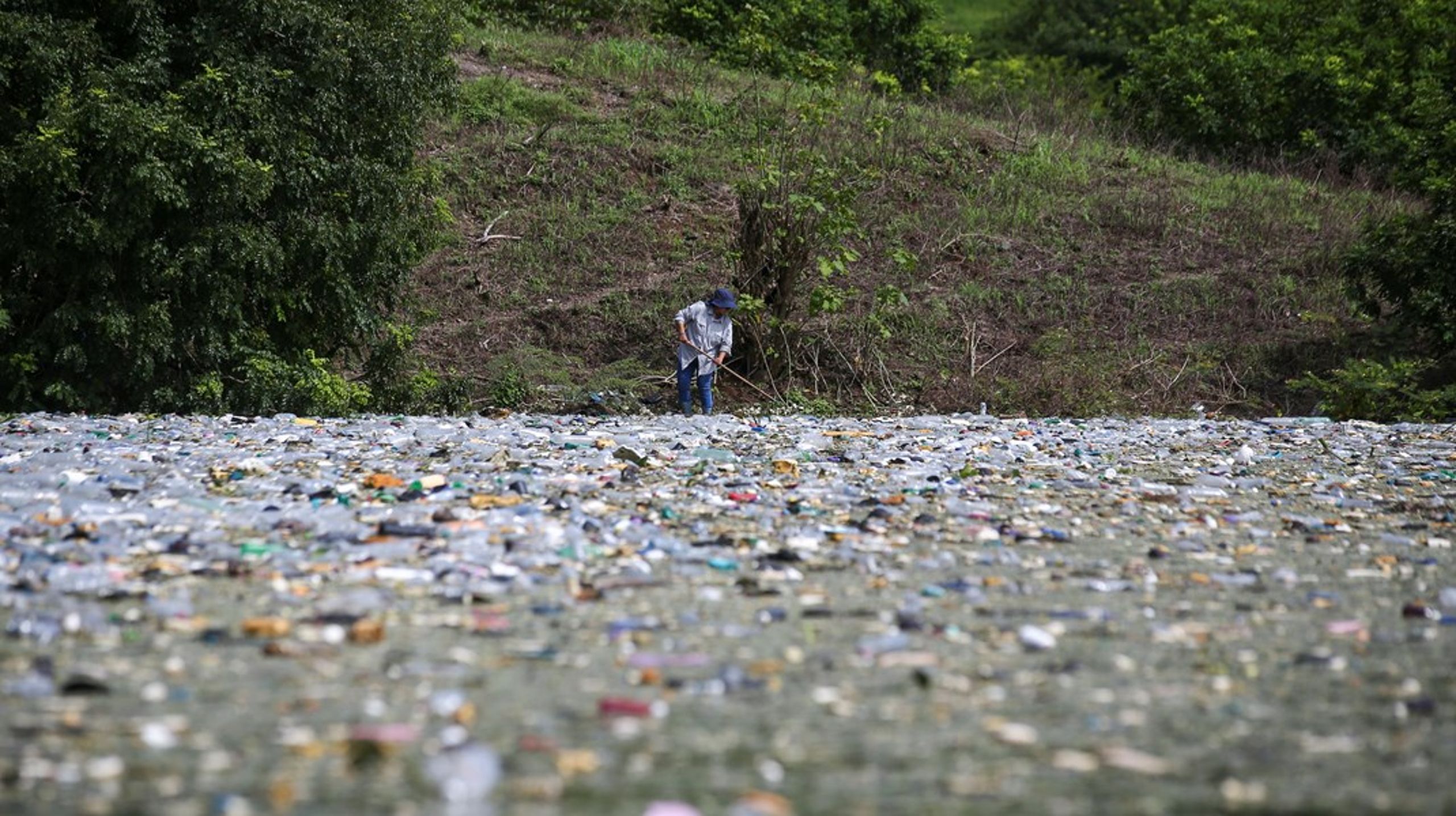 En mann samler inn plastflasker fra El Cerron Grande i El Salvador. Mandag starter det første forhandlingsmøtet om en global plastavtale.&nbsp;